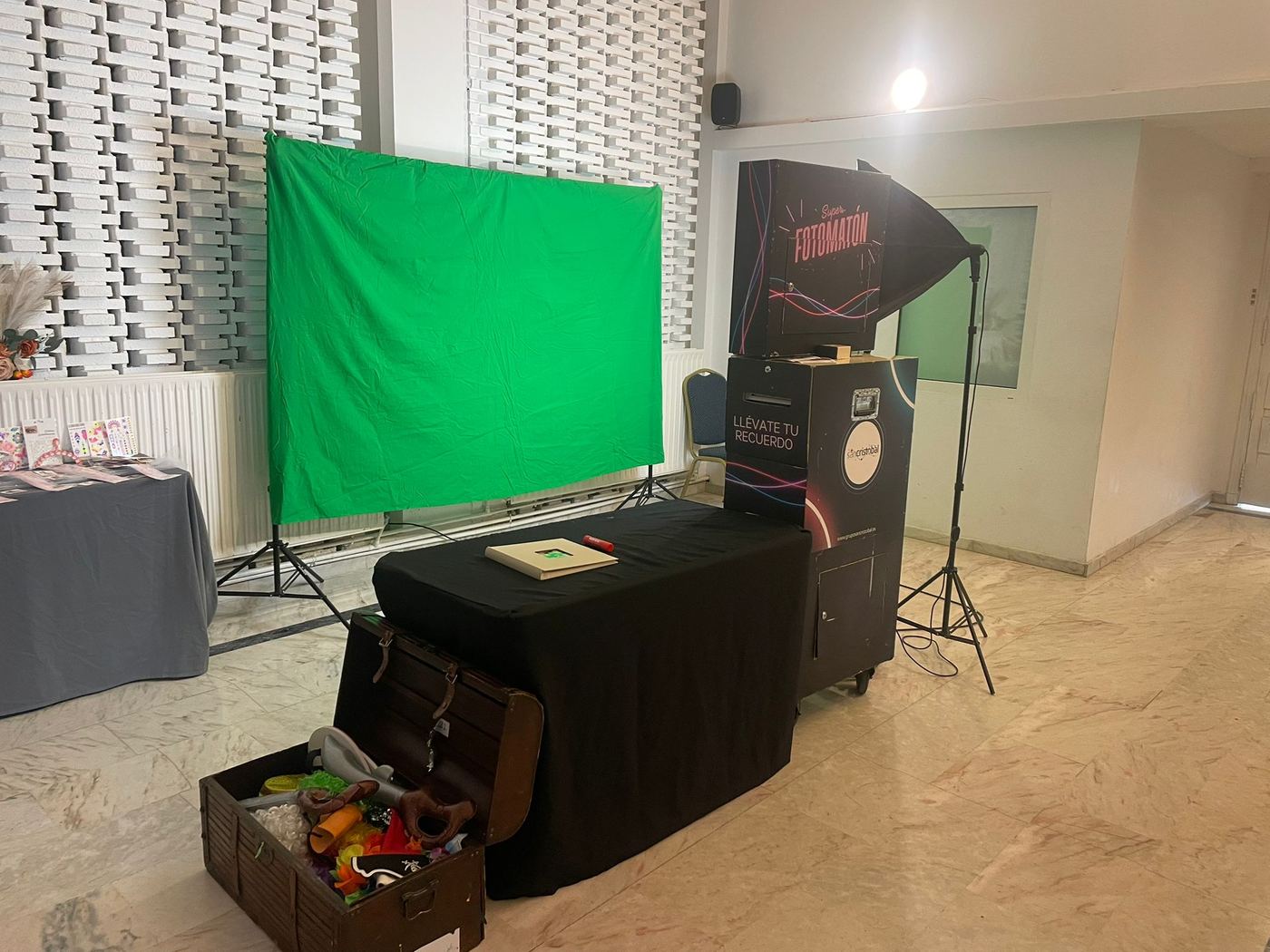 Fotomatón con fondo verde y accesorios para eventos